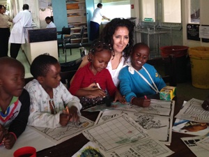 Emina, Dr. Marco's wife, coloring with the children in the hospital